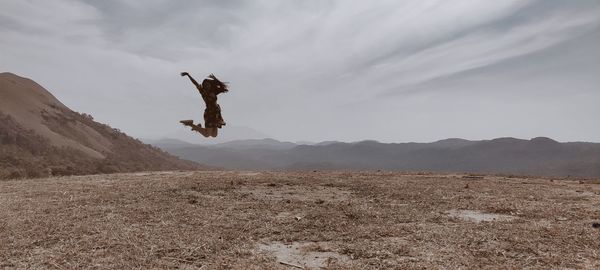 Low angle view of man walking on field against sky