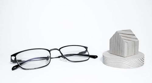 High angle view of eyeglasses on table against white background