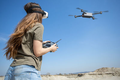 Woman flying a drone with remote controller