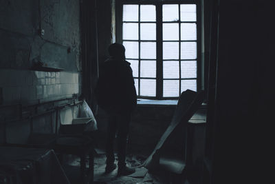 Silhouette man standing in abandoned interior