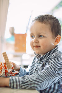 Close-up of cute boy eating food at home