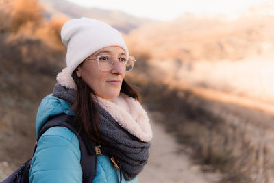 Close up of woman does hiking a sunshine cold day wearing warm clothes and white wood hat