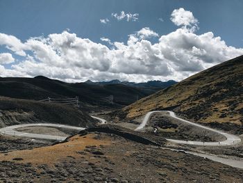 Scenic view of road by mountains against sky