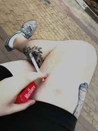 High angle view of person hand with tattoo on table