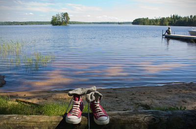 Low section of man on lake against sky