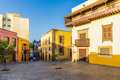 Street amidst buildings against clear sky