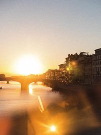 Illuminated city against sky during sunset