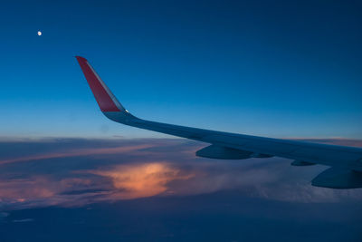 Airplane flying in sky at sunset