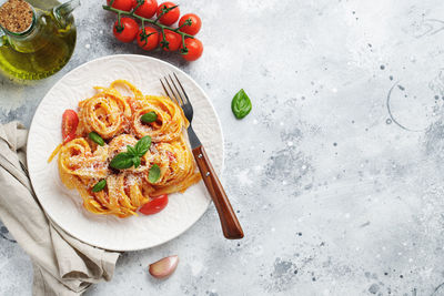 Tasty appetizing classic italian tagliatelle pasta with tomato sauce, cheese parmesan and basil.