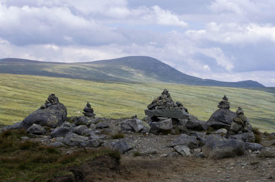 Scenic view of rocks on field against sky