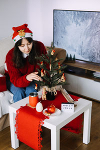 Portrait of smiling young woman sitting at home