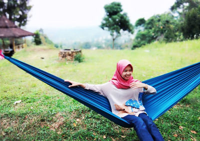 Portrait of smiling young woman lying on field