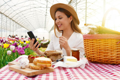 Woman using smart phone in greenhouse