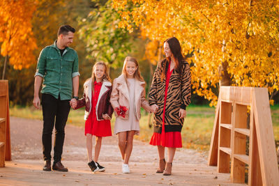 Group of people walking on autumn leaves