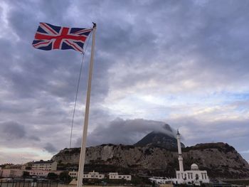 Low angle view of union jack flag waving against sky