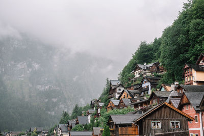 Houses by trees and mountains against sky