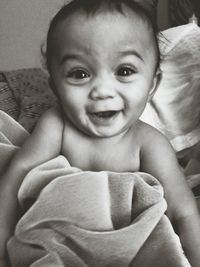 Close-up portrait of cute baby boy on bed