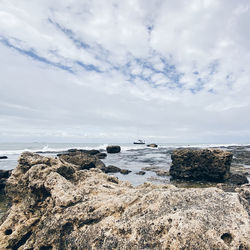 Rocks on beach against sky