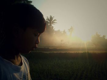 Close-up of woman on field during sunset