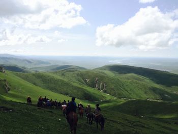 Group of people riding horses on landscape