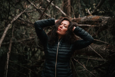 Young woman looking away in forest