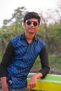 Portrait of young man wearing sunglasses standing outdoors