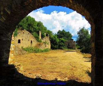 Old ruins of building on field against sky