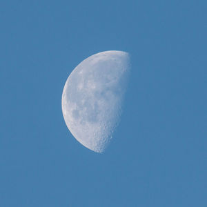 Low angle view of moon against clear blue sky