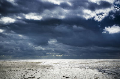 Scenic view of sea against storm clouds