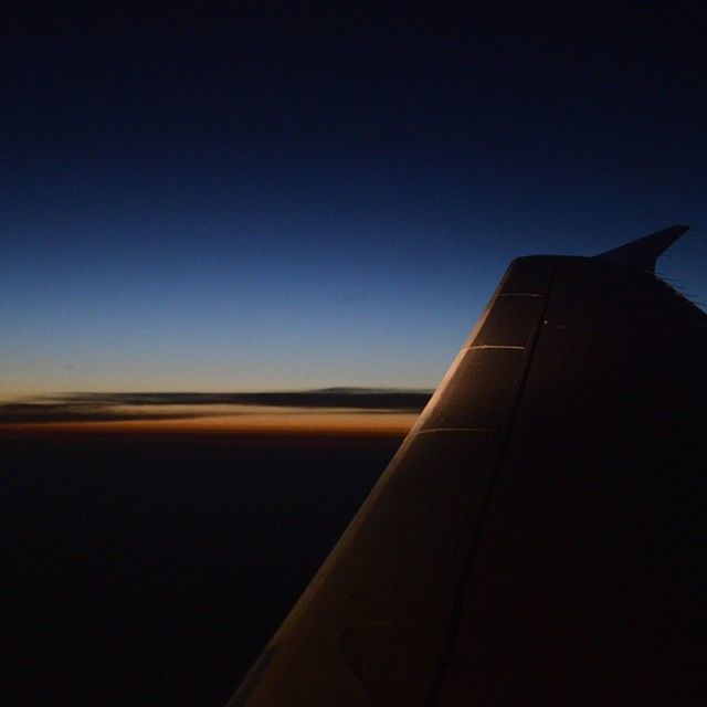 airplane, transportation, copy space, clear sky, mode of transport, air vehicle, part of, sky, sunset, cropped, aircraft wing, blue, travel, no people, flying, outdoors, dusk, landscape, journey, nature