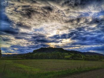 Scenic view of field against cloudy sky