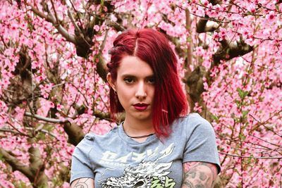 Portrait of young woman standing against plants