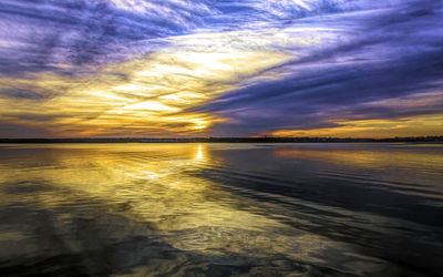 Scenic view of sea against dramatic sky during sunset