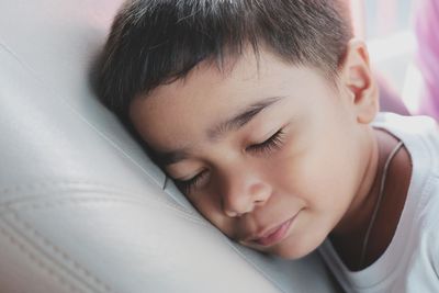 Close-up of cute boy sleeping on bed