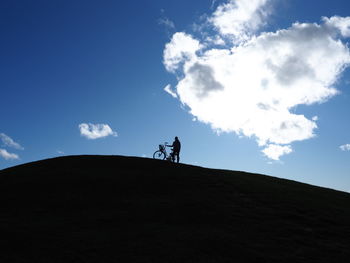 Low angle view of silhouette man standing on land against sky