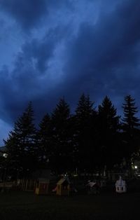 Silhouette trees on landscape against cloudy sky