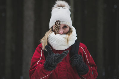 Woman catching pine cone during winter