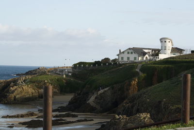 Buildings by sea against sky