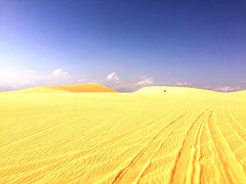 Scenic view of desert against blue sky