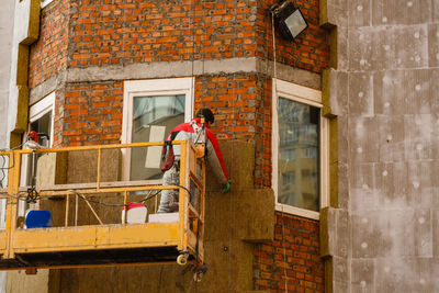 Rear view of woman standing against wall