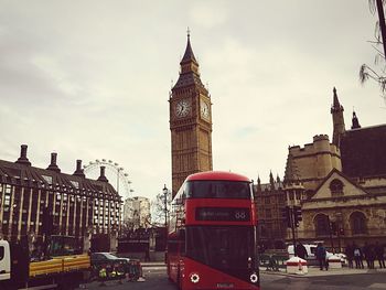 Clock tower in city against cloudy sky