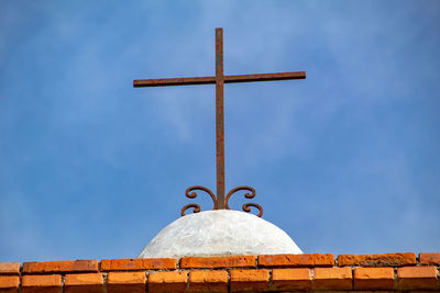 Low angle view of cross against blue sky