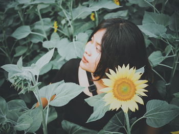 Close-up portrait of woman by flowering plants