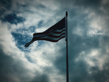 Low angle view of flag against cloudy sky