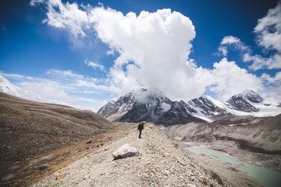 Hiker on hill against sky