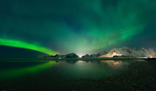 Scenic view of lake and mountains against sky at night