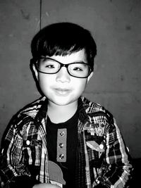 Portrait of boy standing against wall