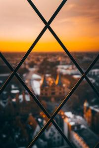 Close-up of chainlink fence against sky during sunset