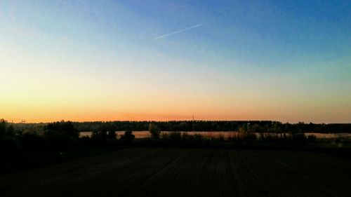 Scenic view of agricultural field against sky during sunset