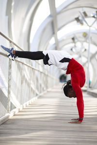 Athlete doing handstand while exercising on walkway